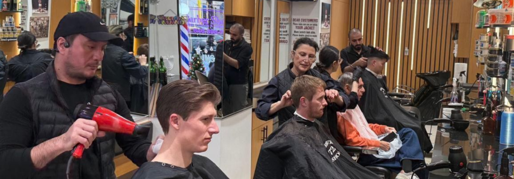 Barbers working on clients during a busy shift at Barbershop 72