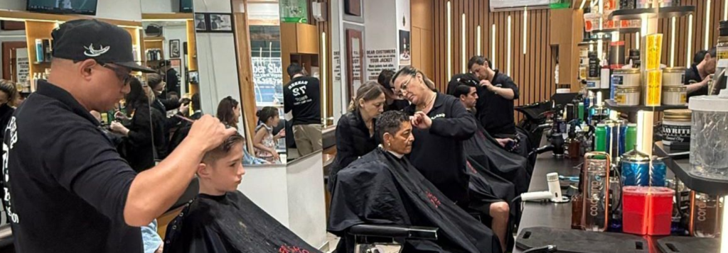 Barber carefully trimming a client’s hair inside Barbershop 72